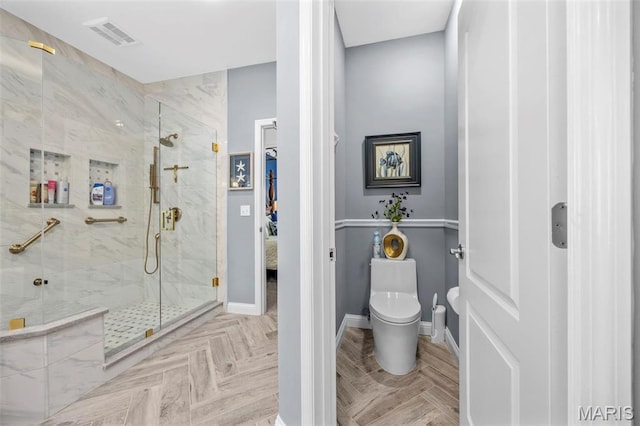 bathroom featuring a marble finish shower, toilet, and baseboards