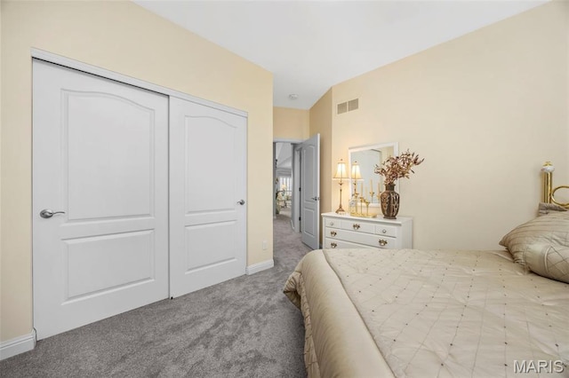 carpeted bedroom featuring a closet and baseboards