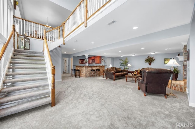 living room with carpet flooring, stairway, recessed lighting, baseboards, and a towering ceiling