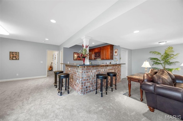 kitchen with open floor plan, a breakfast bar, light colored carpet, recessed lighting, and baseboards