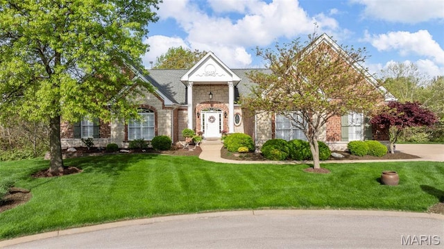 greek revival inspired property with stone siding and a front yard