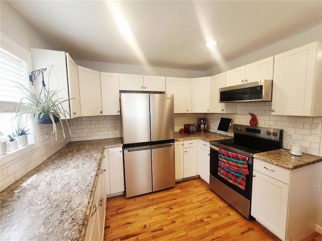 1104 Ringo St, Mexico, MO 65265 - kitchen with stainless steel appliances, healthy amount of natural light, backsplash, and white cabinetry
