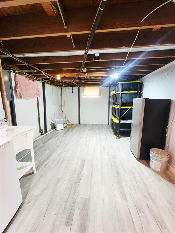 1104 Ringo St, Mexico, MO 65265 - unfinished basement featuring freestanding refrigerator and wood finished floors