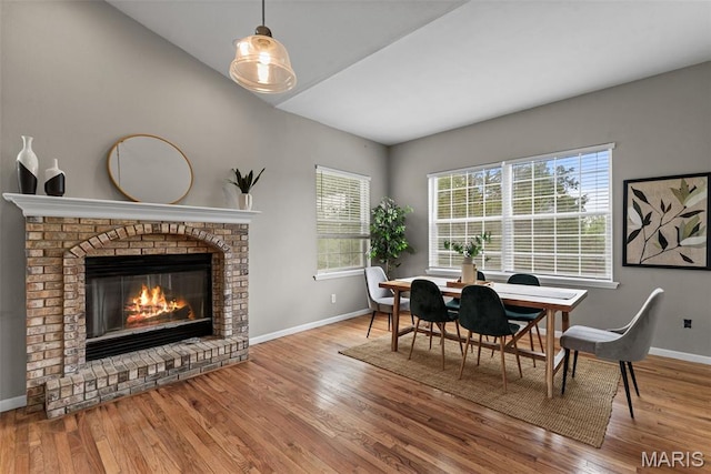 122 Morgan Lake Rd, De Soto, MO 63020 - dining area featuring baseboards, vaulted ceiling, wood finished floors, and a brick fireplace