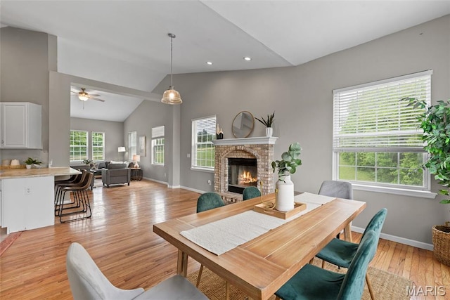 122 Morgan Lake Rd, De Soto, MO 63020 - dining space featuring vaulted ceiling, light wood-type flooring, ceiling fan, a brick fireplace, and baseboards