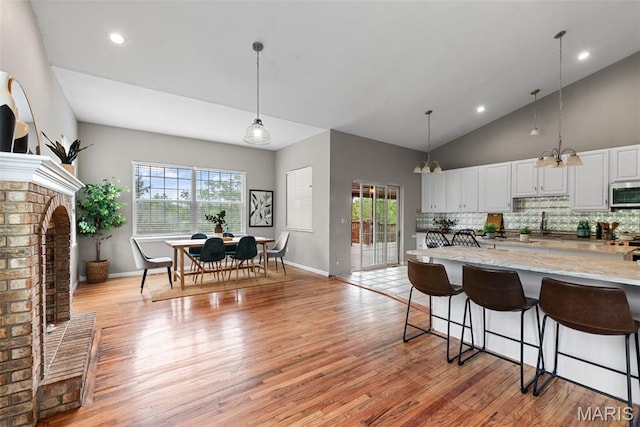 122 Morgan Lake Rd, De Soto, MO 63020 - kitchen featuring stainless steel microwave, light wood-style flooring, a breakfast bar, plenty of natural light, and recessed lighting
