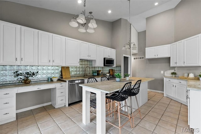 122 Morgan Lake Rd, De Soto, MO 63020 - kitchen featuring stainless steel appliances, a towering ceiling, light tile patterned flooring, tasteful backsplash, and a sink