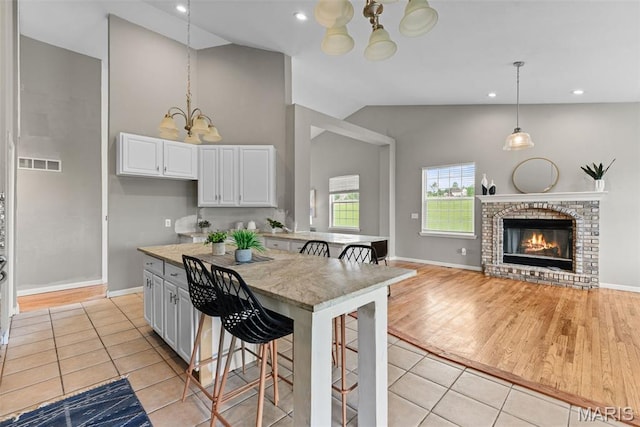122 Morgan Lake Rd, De Soto, MO 63020 - kitchen with a chandelier, a kitchen bar, light tile patterned flooring, white cabinetry, and recessed lighting
