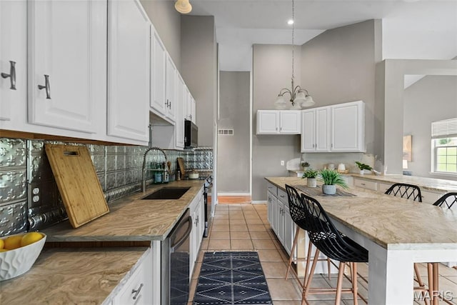 122 Morgan Lake Rd, De Soto, MO 63020 - kitchen featuring a sink, appliances with stainless steel finishes, a chandelier, backsplash, and a breakfast bar area