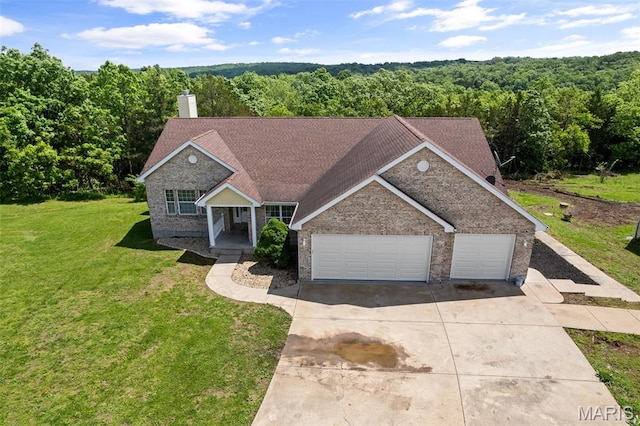 122 Morgan Lake Rd, De Soto, MO 63020 - view of front facade with concrete driveway, a view of trees, an attached garage, and a front yard