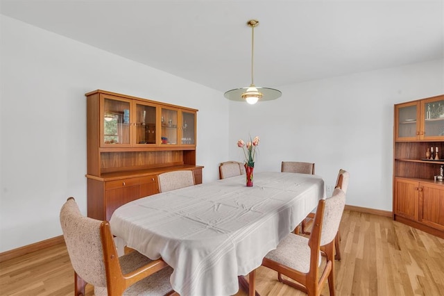 dining area featuring light wood finished floors and baseboards