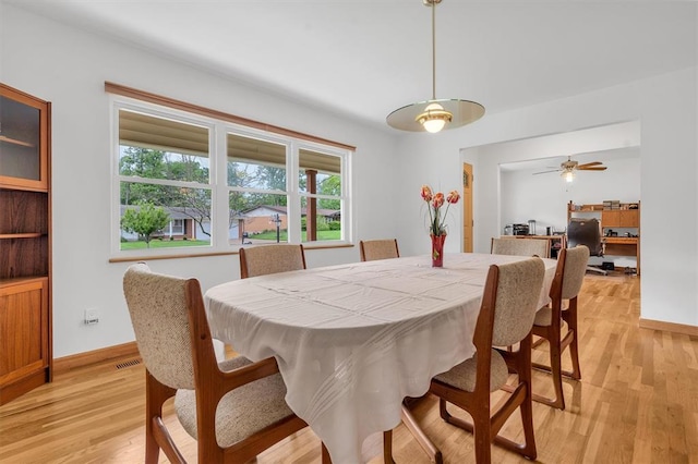 dining area featuring light wood-style flooring, baseboards, and a ceiling fan