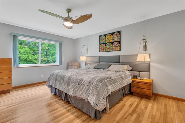 bedroom with light wood-type flooring, baseboards, and ceiling fan