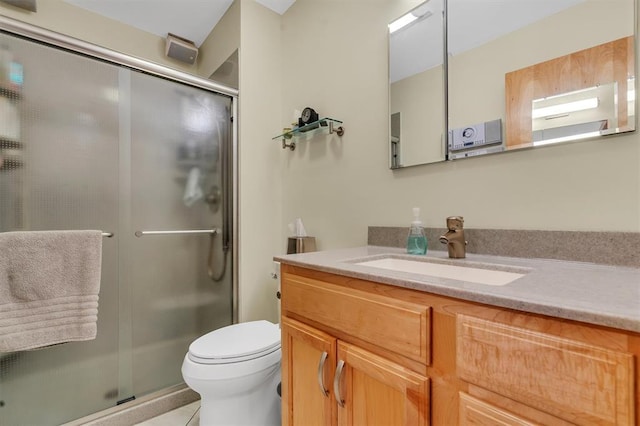bathroom featuring toilet, tile patterned flooring, a shower stall, and vanity