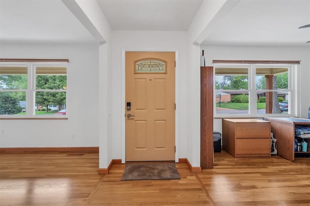 entryway with light wood finished floors and baseboards