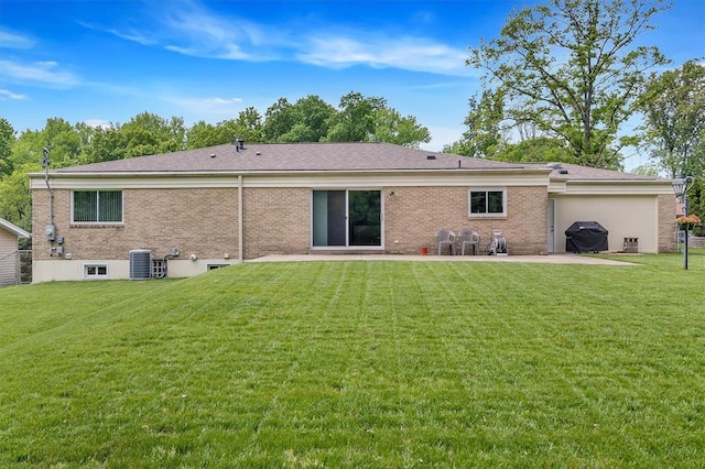 rear view of house with a patio, cooling unit, a yard, and brick siding