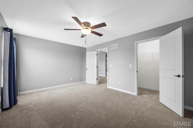 137 Countryshire Dr, Lake St Louis, MO 63367 - unfurnished bedroom with carpet floors, baseboards, a walk in closet, and a ceiling fan