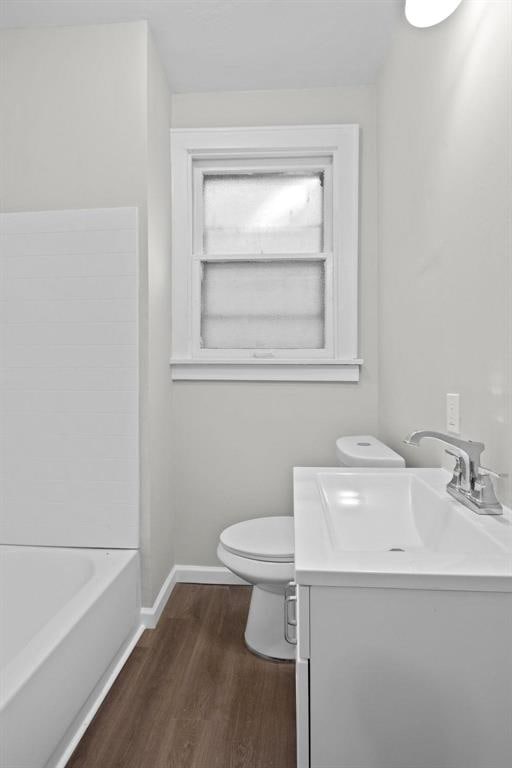 5039 Grace Ave, Saint Louis, MO 63116 - full bathroom featuring toilet, wood finished floors, a bath, baseboards, and vanity