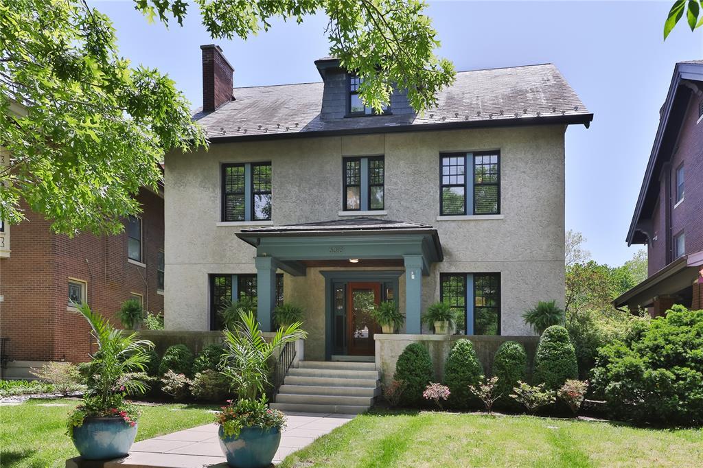 6318 Waterman Ave, University City, MO 63130 - view of front of house with stucco siding, a chimney, a front yard, and a high end roof