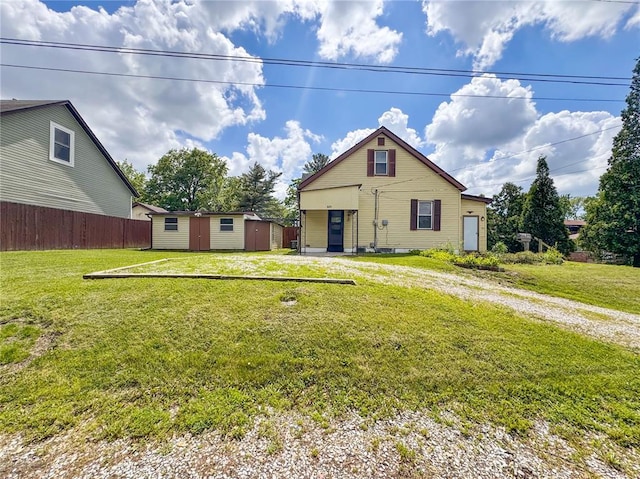 rear view of house featuring a storage unit, an outbuilding, and driveway