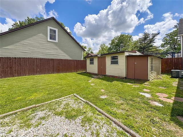 view of yard featuring a storage unit, an outdoor structure, and central air condition unit