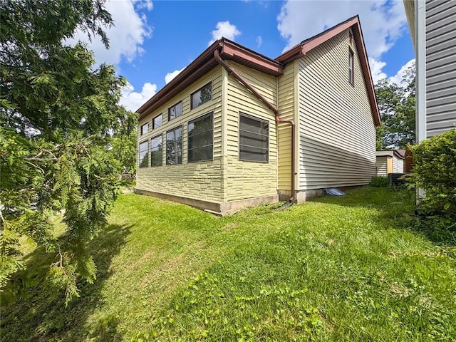 view of side of home with a lawn and stone siding