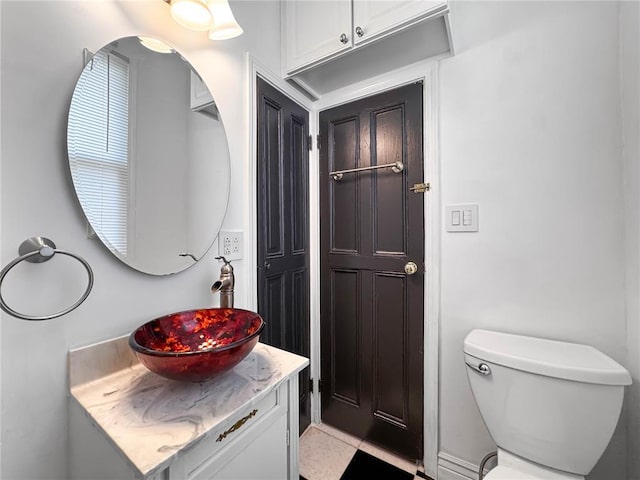 half bath featuring vanity and toilet