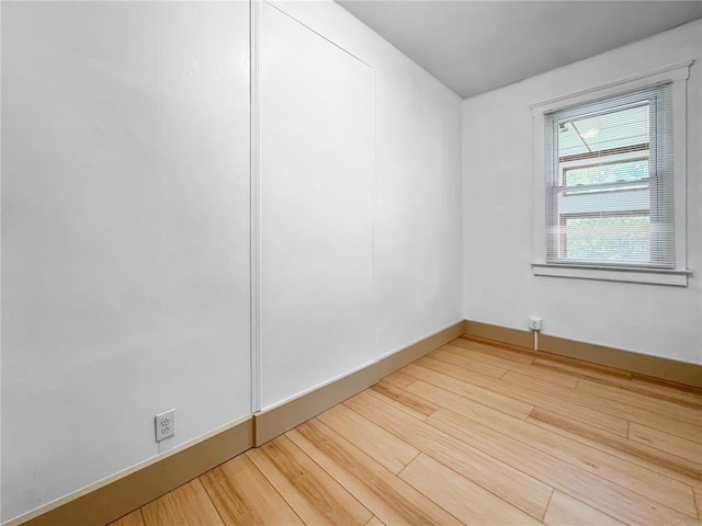 spare room with light wood-type flooring and baseboards