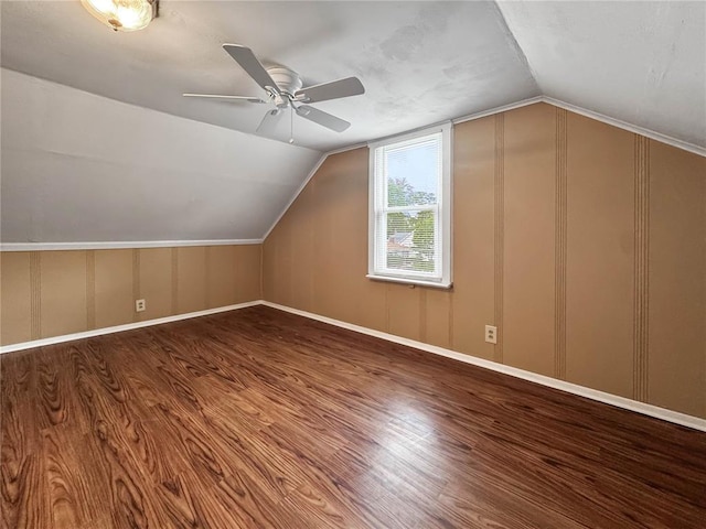 additional living space with wood finished floors, ceiling fan, lofted ceiling, and a decorative wall