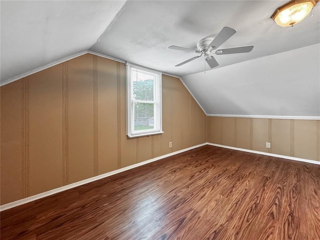 bonus room with a ceiling fan, wood finished floors, vaulted ceiling, a decorative wall, and baseboards