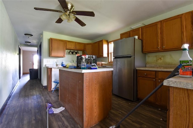 880 W Nicholas St, Carlinville, IL 62626 - kitchen with freestanding refrigerator, dark wood-style flooring, light countertops, brown cabinetry, and a ceiling fan