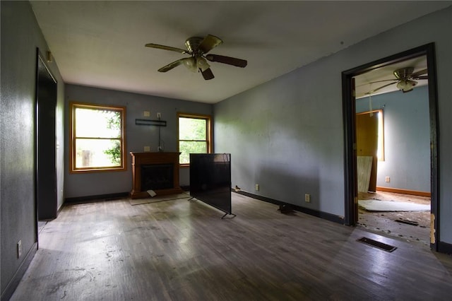 880 W Nicholas St, Carlinville, IL 62626 - unfurnished living room featuring a ceiling fan, wood finished floors, baseboards, and a fireplace