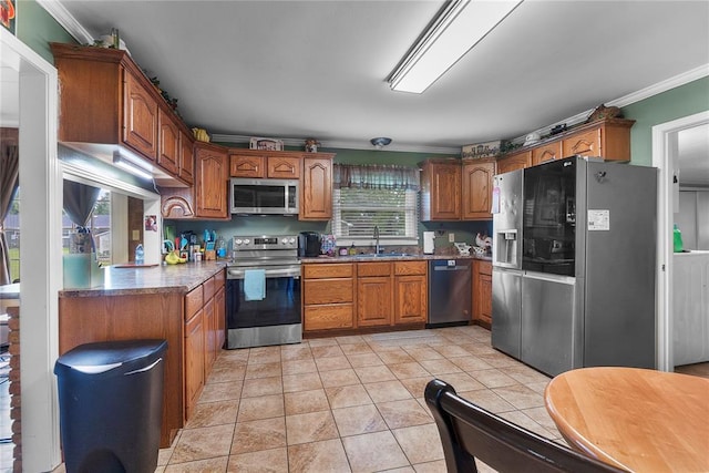 102 E Charlotte, Lilbourn, MO 63862 - kitchen with appliances with stainless steel finishes, a sink, ornamental molding, brown cabinets, and light tile patterned floors