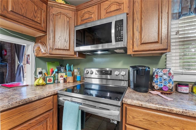 102 E Charlotte, Lilbourn, MO 63862 - kitchen with appliances with stainless steel finishes, brown cabinetry, and tile patterned flooring
