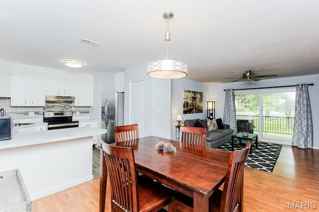 10077 N Bunker Hill Dr Unit F, Mehlville, MO 63123 - dining area featuring light wood-style floors and a ceiling fan