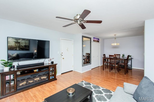 10077 N Bunker Hill Dr Unit F, Mehlville, MO 63123 - living area with wood finished floors, a ceiling fan, and a chandelier