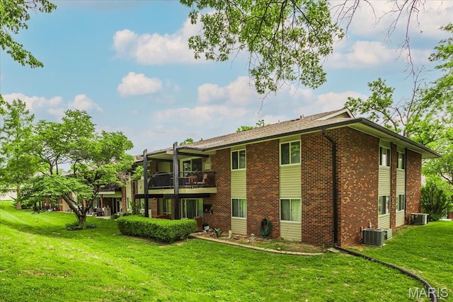 10077 N Bunker Hill Dr Unit F, Mehlville, MO 63123 - rear view of property featuring brick siding, a yard, and a balcony