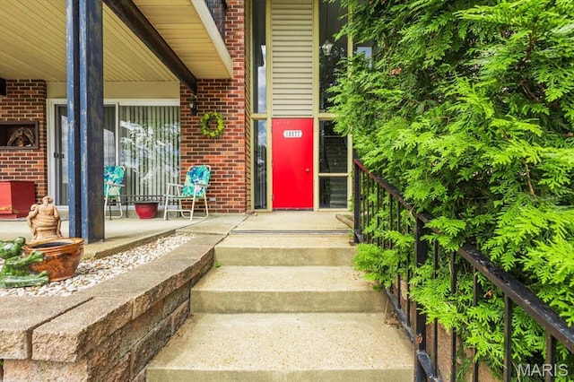 10077 N Bunker Hill Dr Unit F, Mehlville, MO 63123 - entrance to property with brick siding and a porch