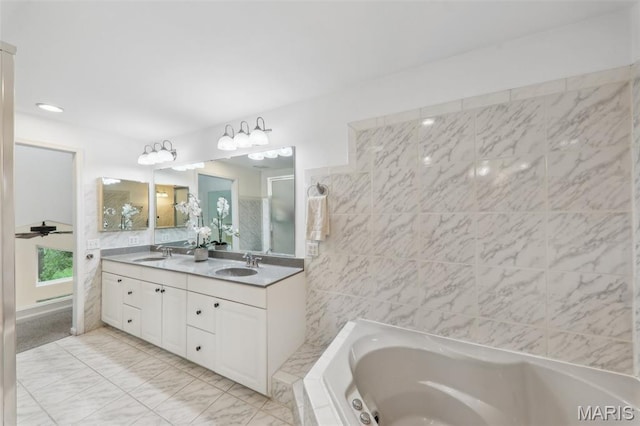 200 Hibler Oaks Dr, Creve Coeur, MO 63141 - bathroom with double vanity, a garden tub, tile walls, and a shower