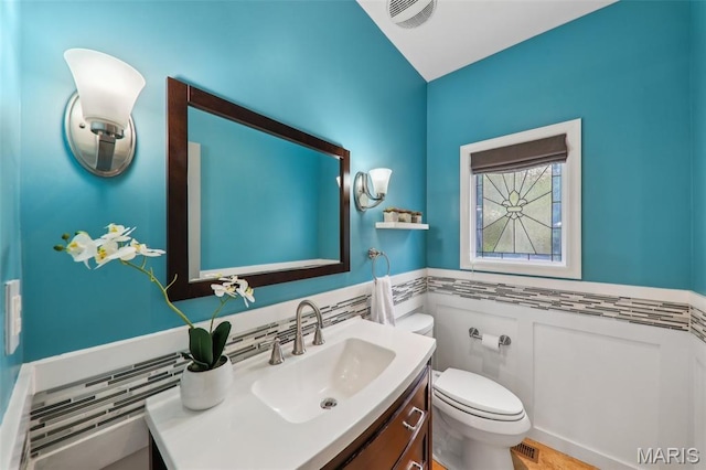 200 Hibler Oaks Dr, Creve Coeur, MO 63141 - half bathroom featuring vanity, toilet, and a wainscoted wall