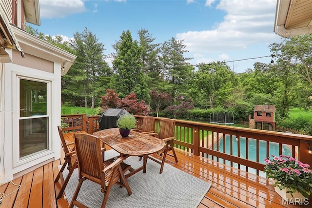200 Hibler Oaks Dr, Creve Coeur, MO 63141 - deck featuring outdoor dining area, a trampoline, and view of scattered trees