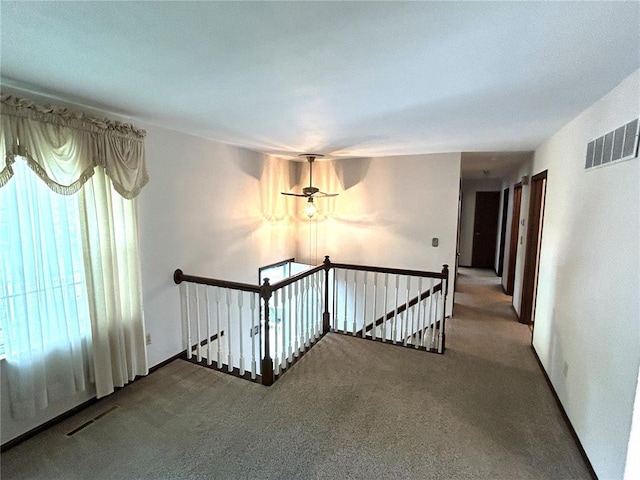 hall featuring an upstairs landing and carpet