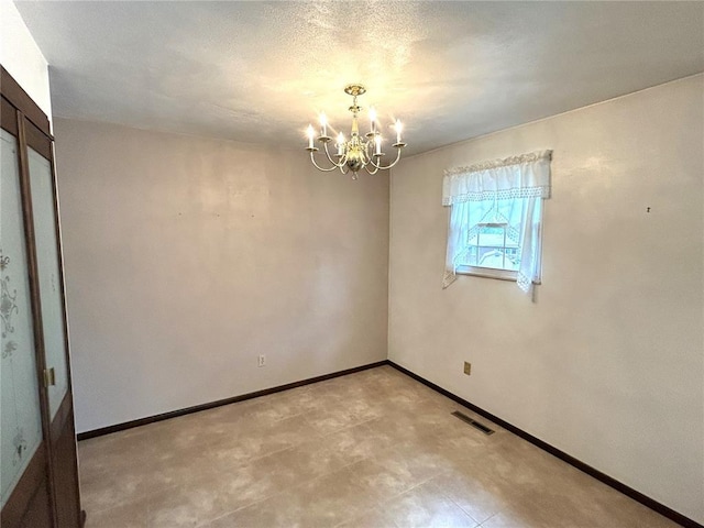 empty room with a chandelier and baseboards