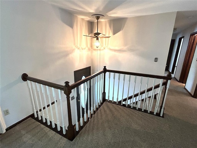 stairway featuring carpet flooring, ceiling fan, and baseboards