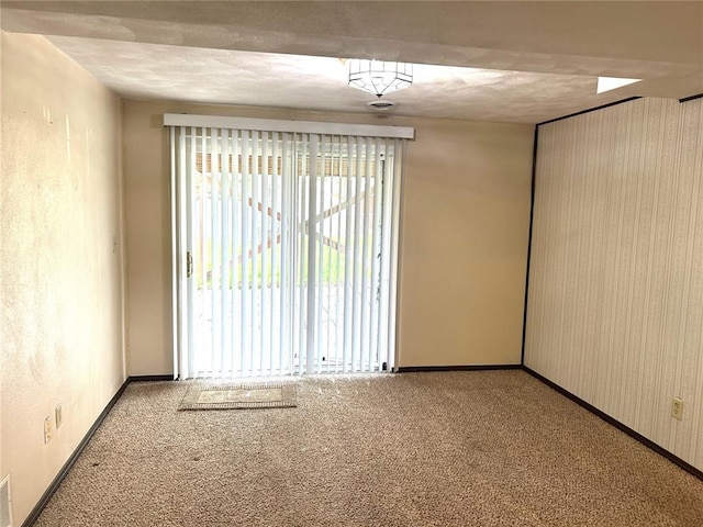 unfurnished room featuring carpet, baseboards, and a textured ceiling