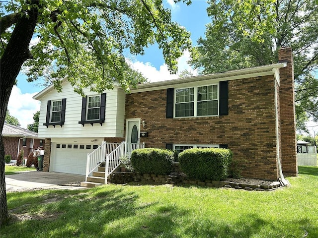 raised ranch featuring a chimney, brick siding, concrete driveway, a front yard, and a garage