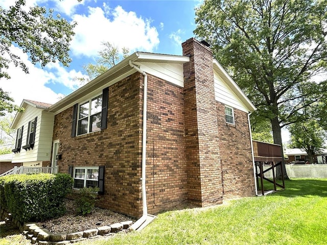 view of property exterior featuring a chimney and brick siding
