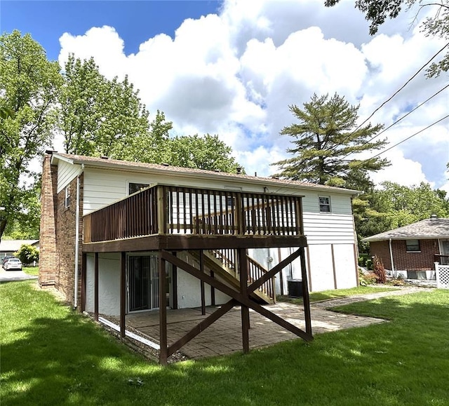 back of property with a wooden deck, a yard, stairs, and a chimney