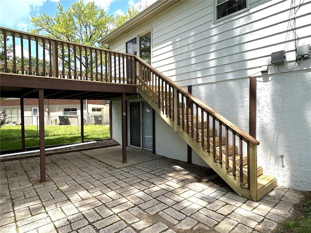 view of patio / terrace with stairs, fence, and a deck
