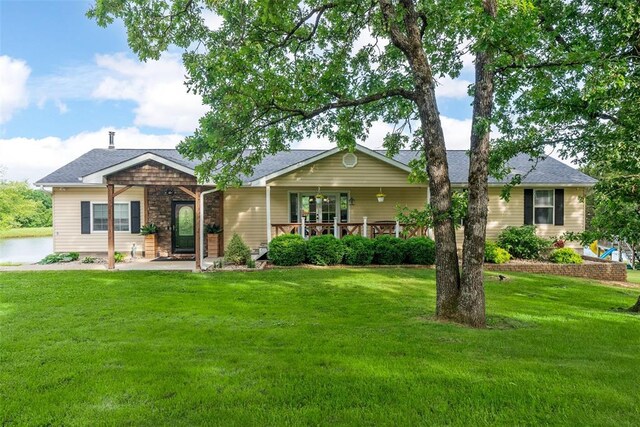 12930 Mohawk Dr, De Soto, MO 63020 - view of front of home with a front yard, stone siding, and roof with shingles